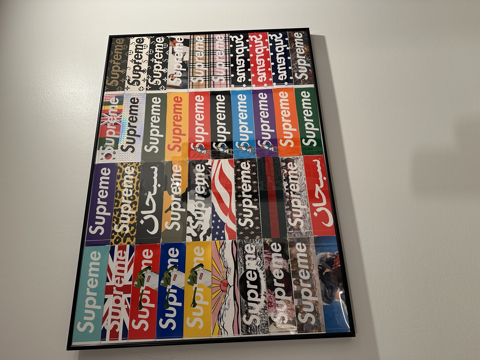 Wall display of framed box-logo sticker compositions