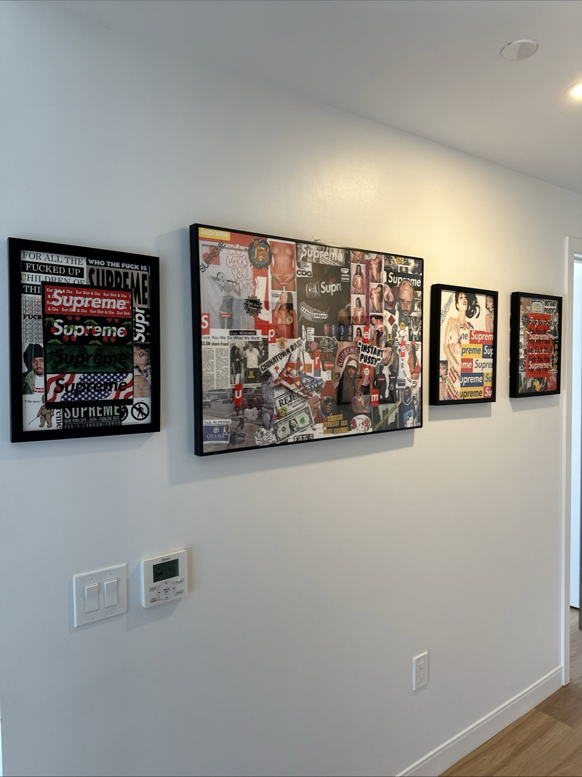 Hallway lined with four framed collages built from Supreme stickers and magazine imagery